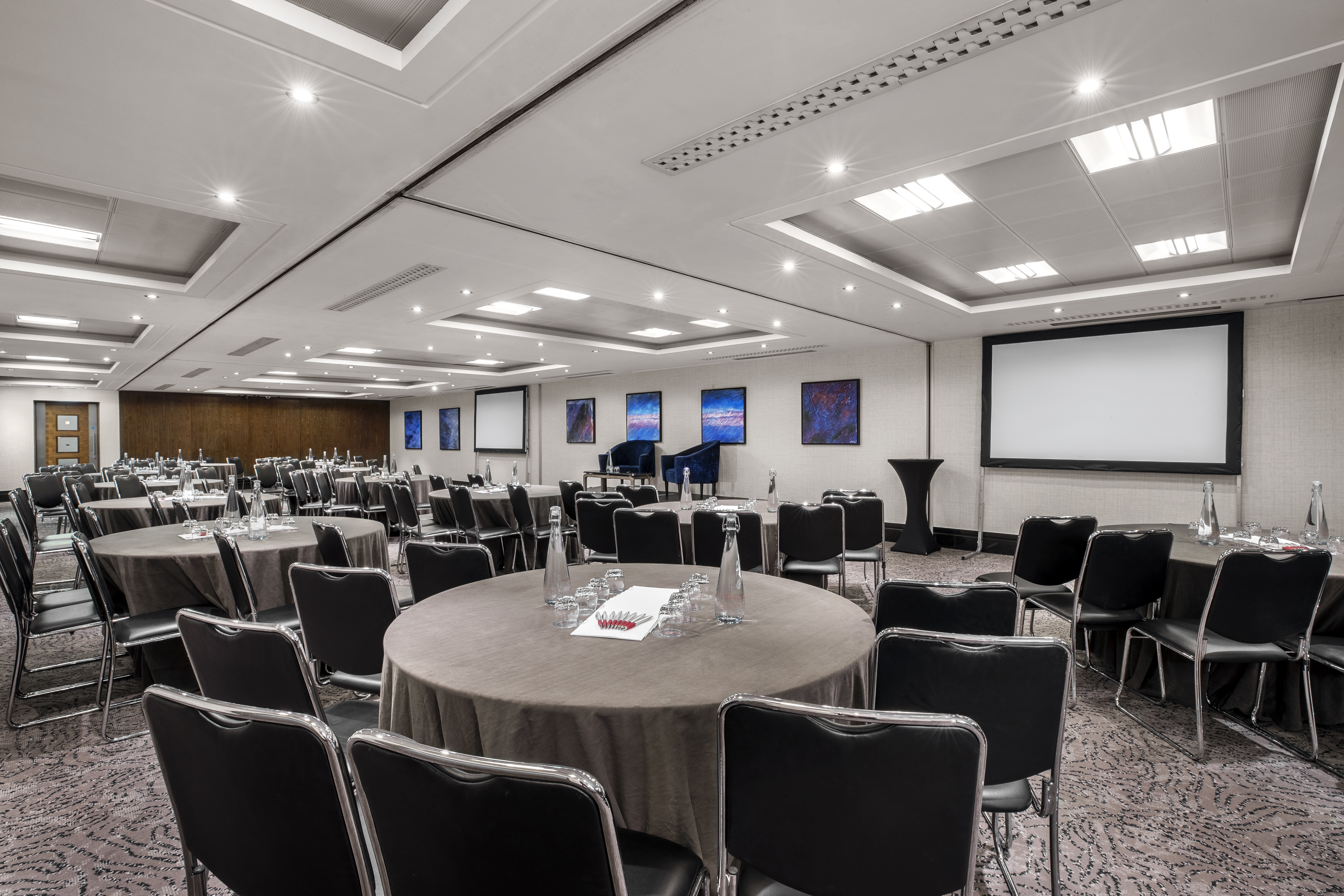 Milton Suite at Leonardo Royal Hotel London: modern meeting space with round tables.