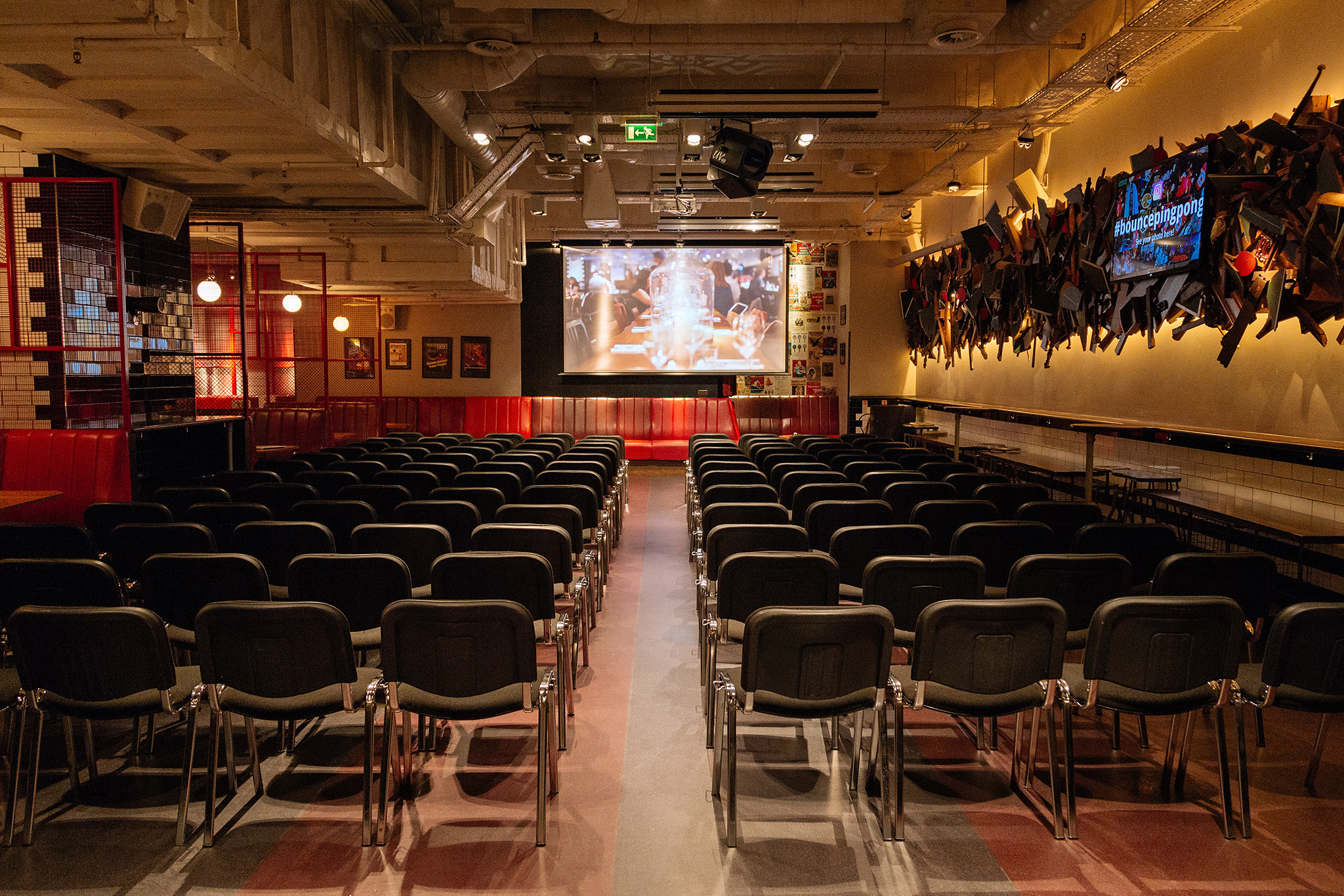 Conference space with black chairs and large screen for corporate meetings and workshops.