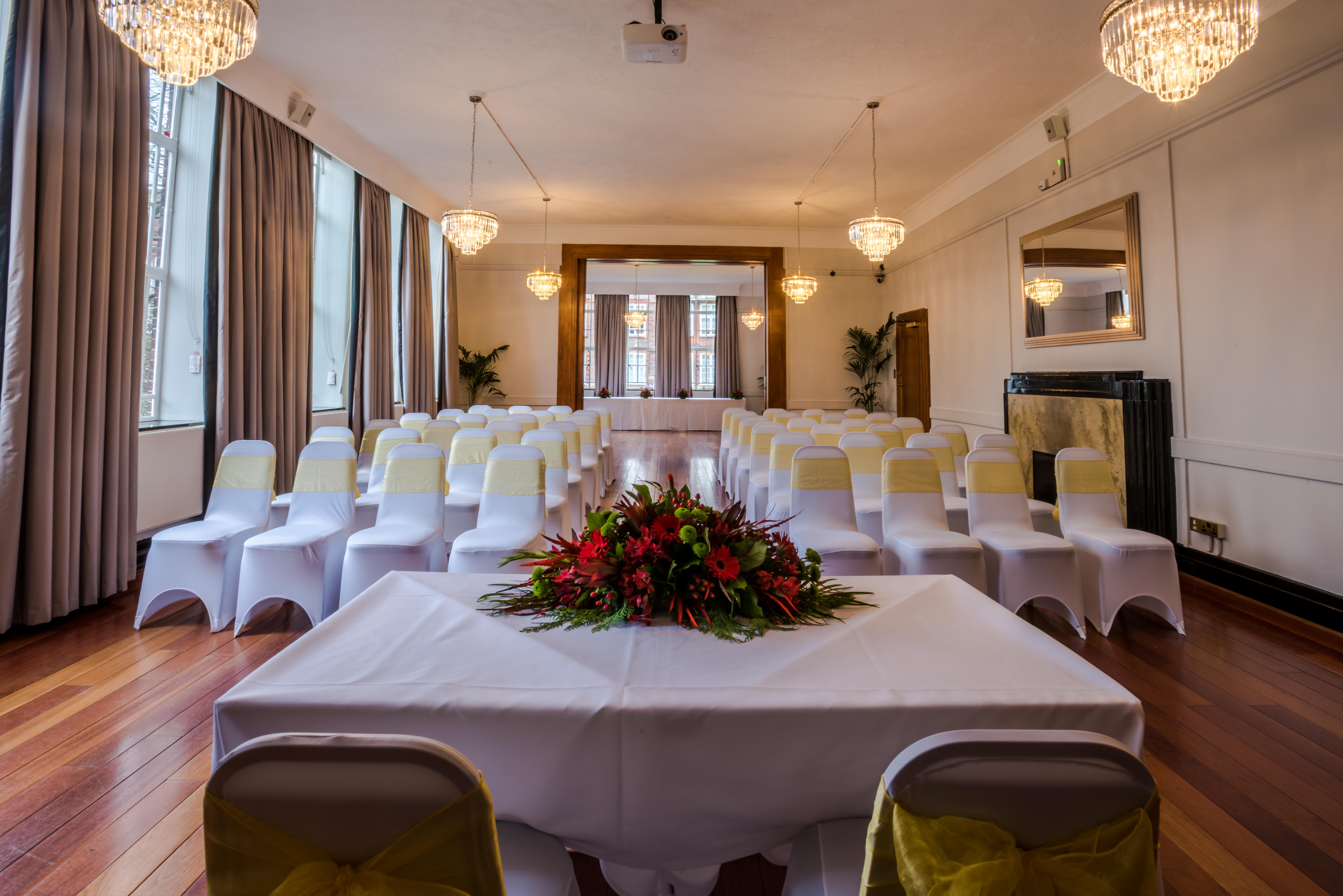 Tuke Common Room event space with elegant chairs and floral centerpiece for meetings and celebrations.
