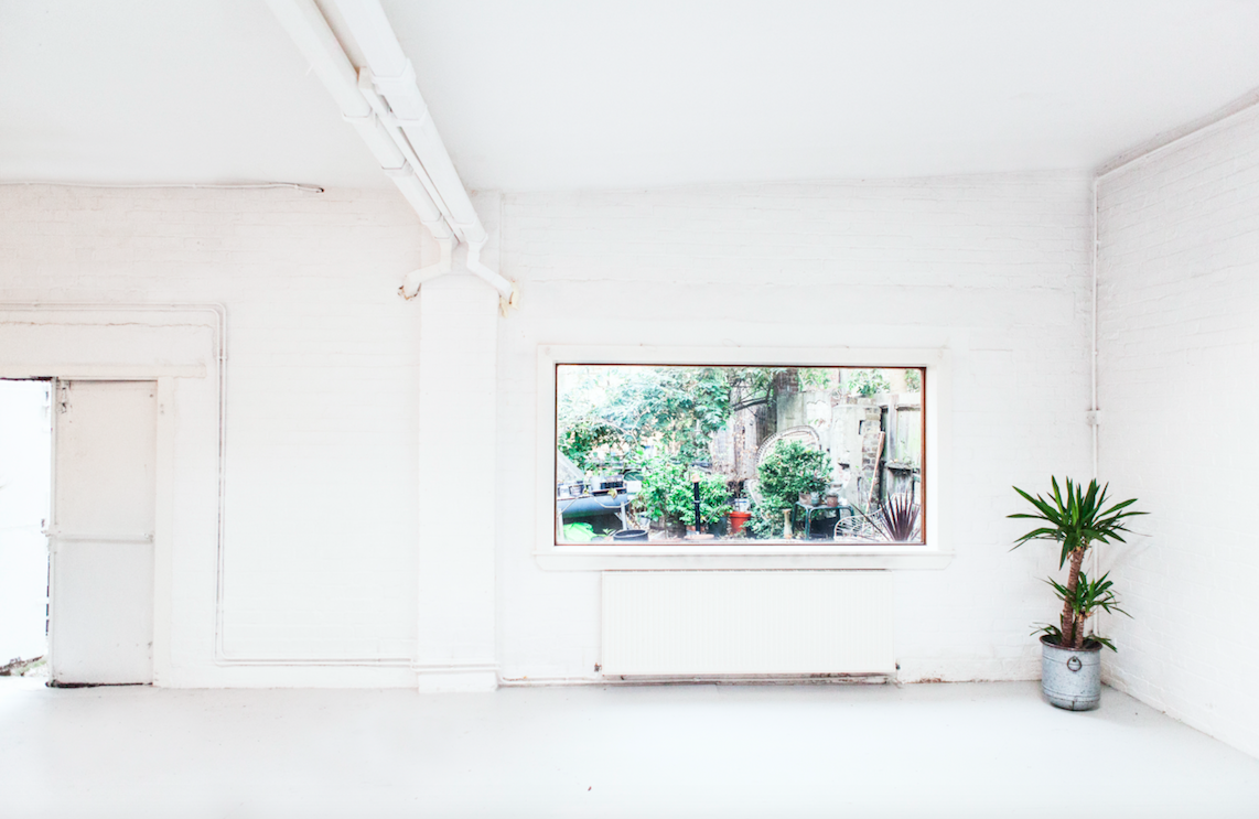 Bright minimalist event space with natural light, ideal for meetings and gatherings.