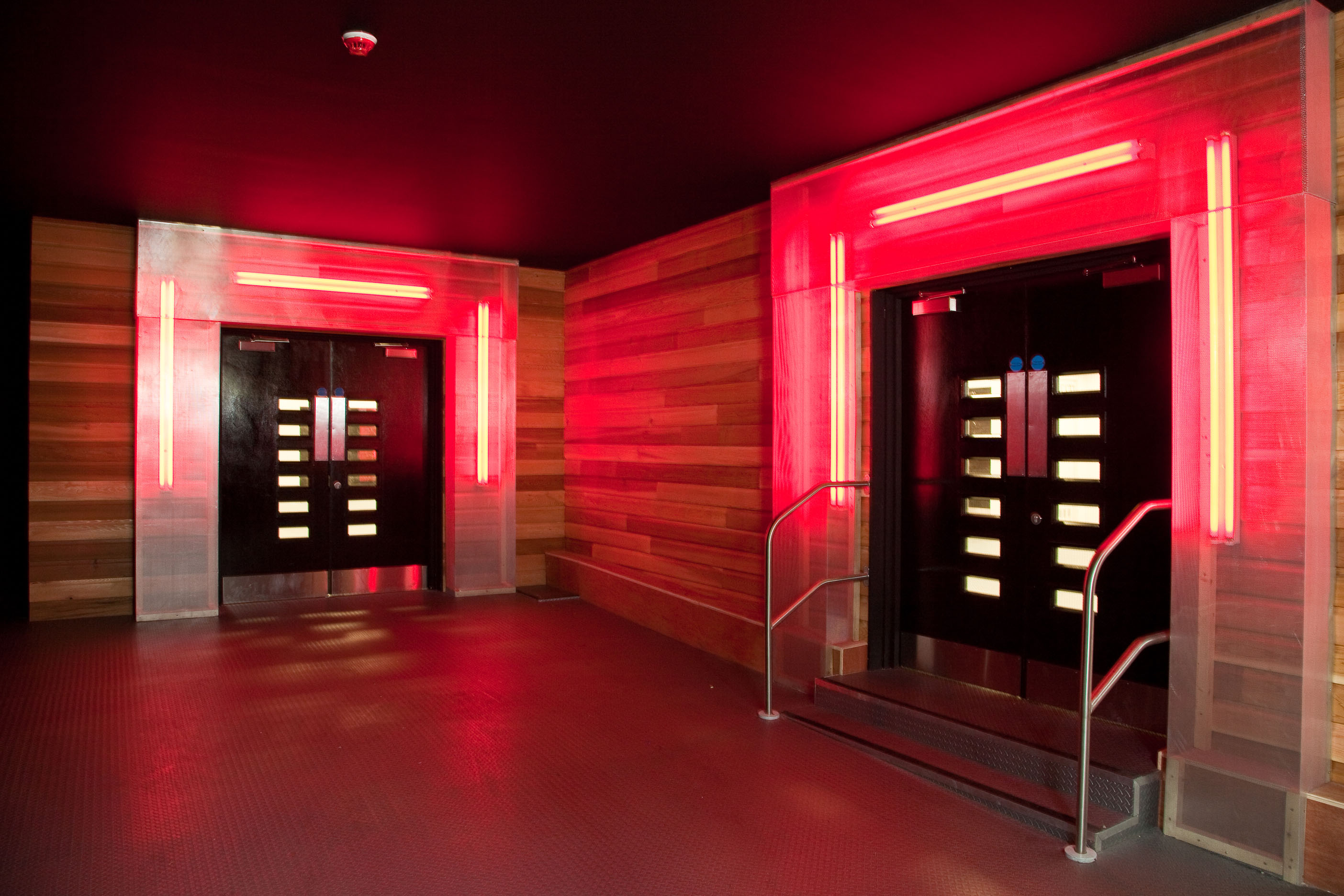 Modern venue entrance with red lighting, ideal for high-energy events and nightlife.
