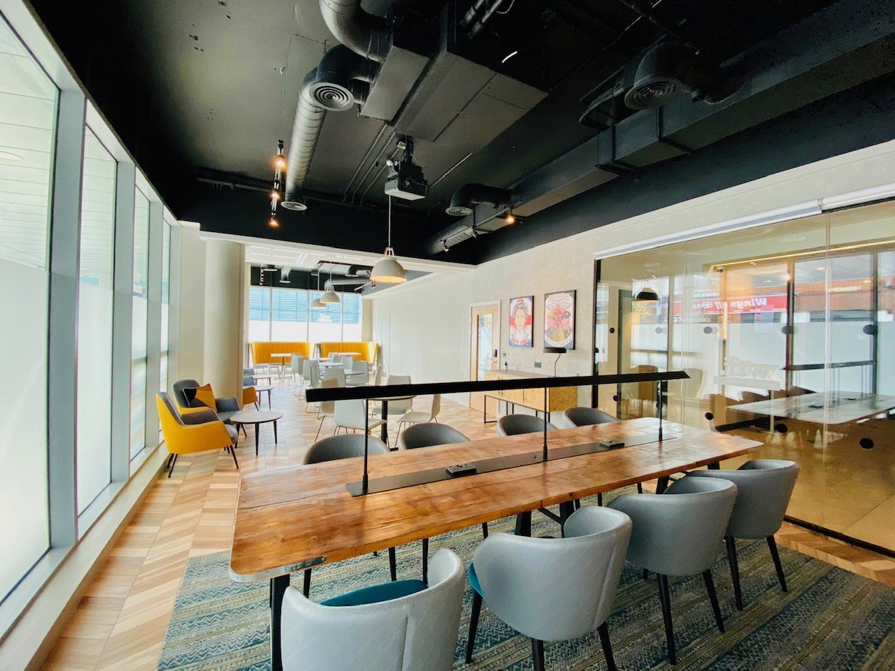 Modern meeting space at Holiday Inn Whitechapel with large wooden table for collaboration. - Banner