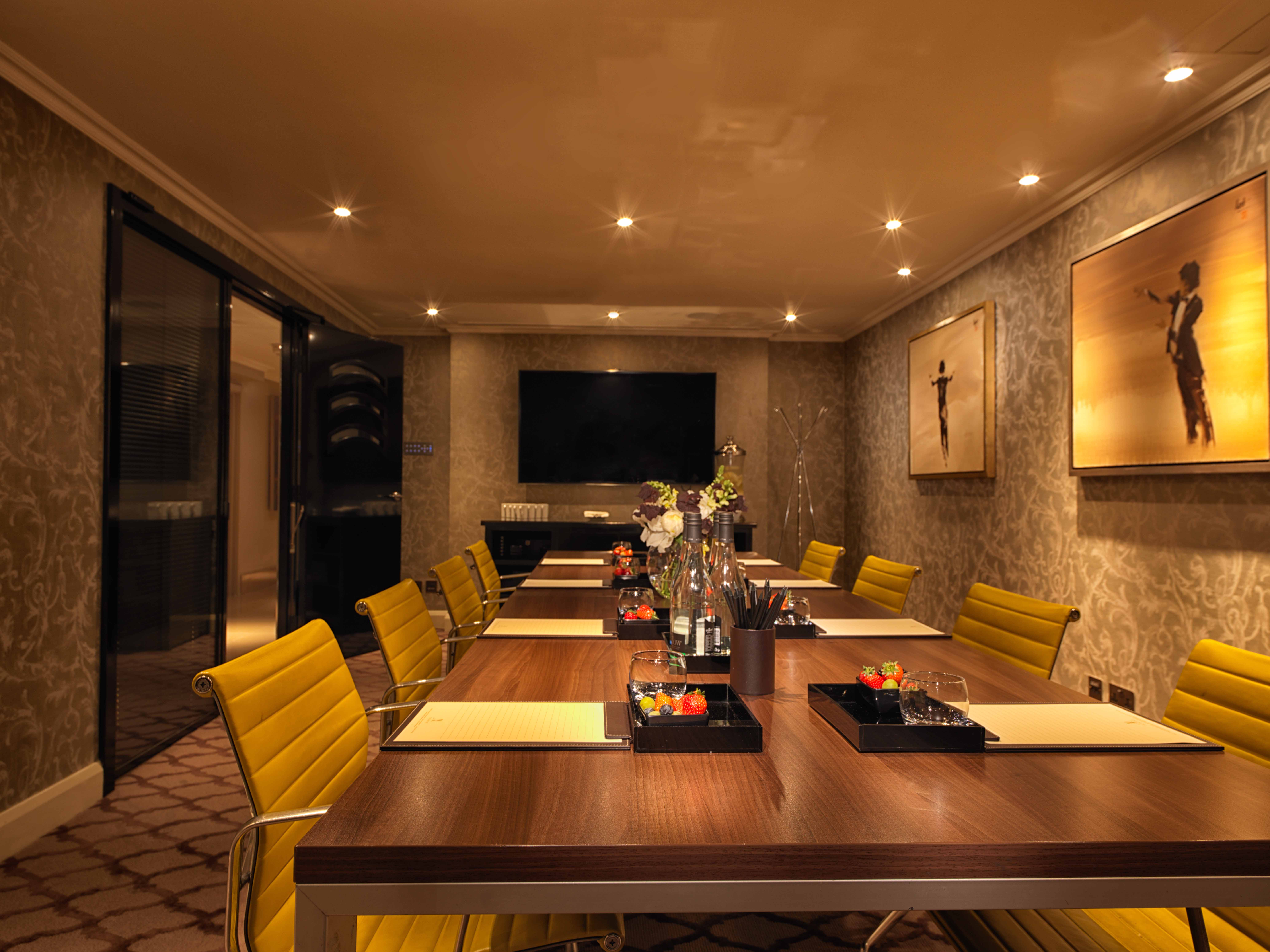 Private Suite 9 at The May Fair Hotel, elegant meeting room with wooden table and yellow chairs.