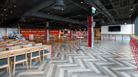 Modern event space at Anfield Beat, Liverpool FC with herringbone flooring for gatherings.