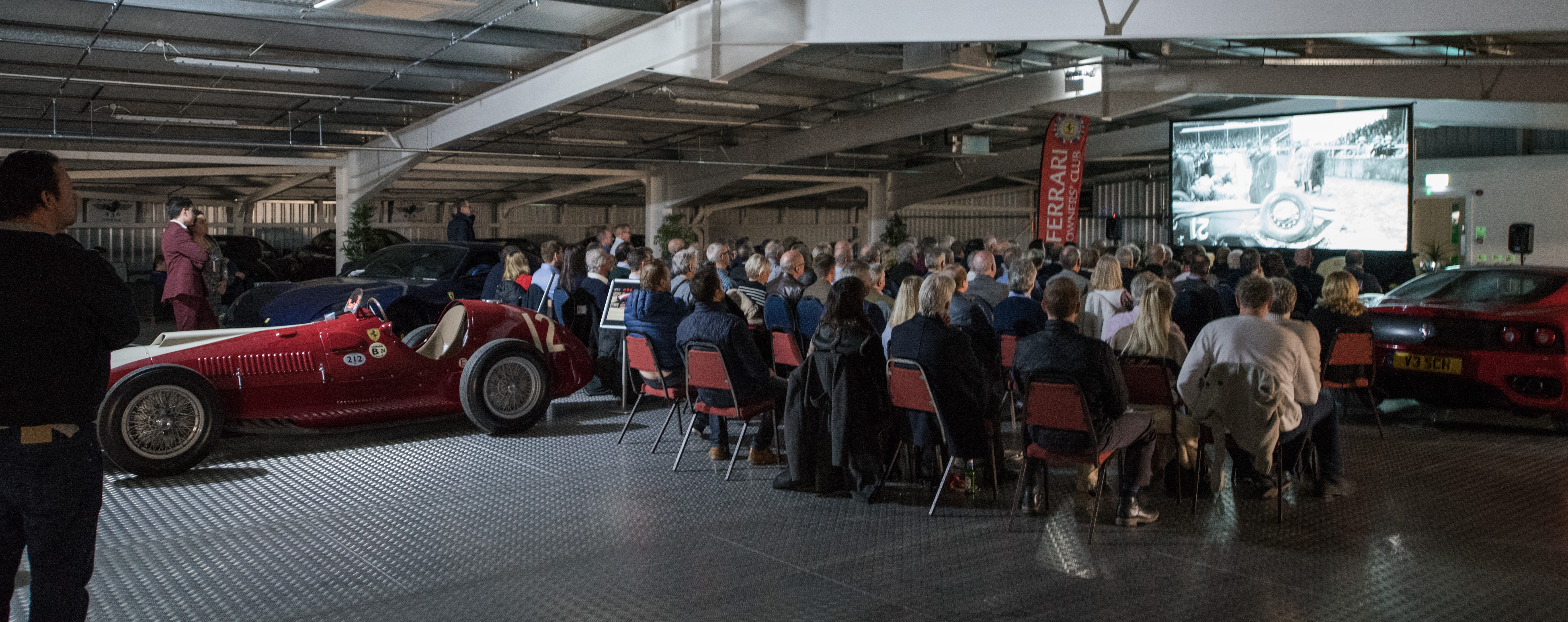 Spacious garage event with vintage car, perfect for automotive and luxury brand gatherings. - Banner