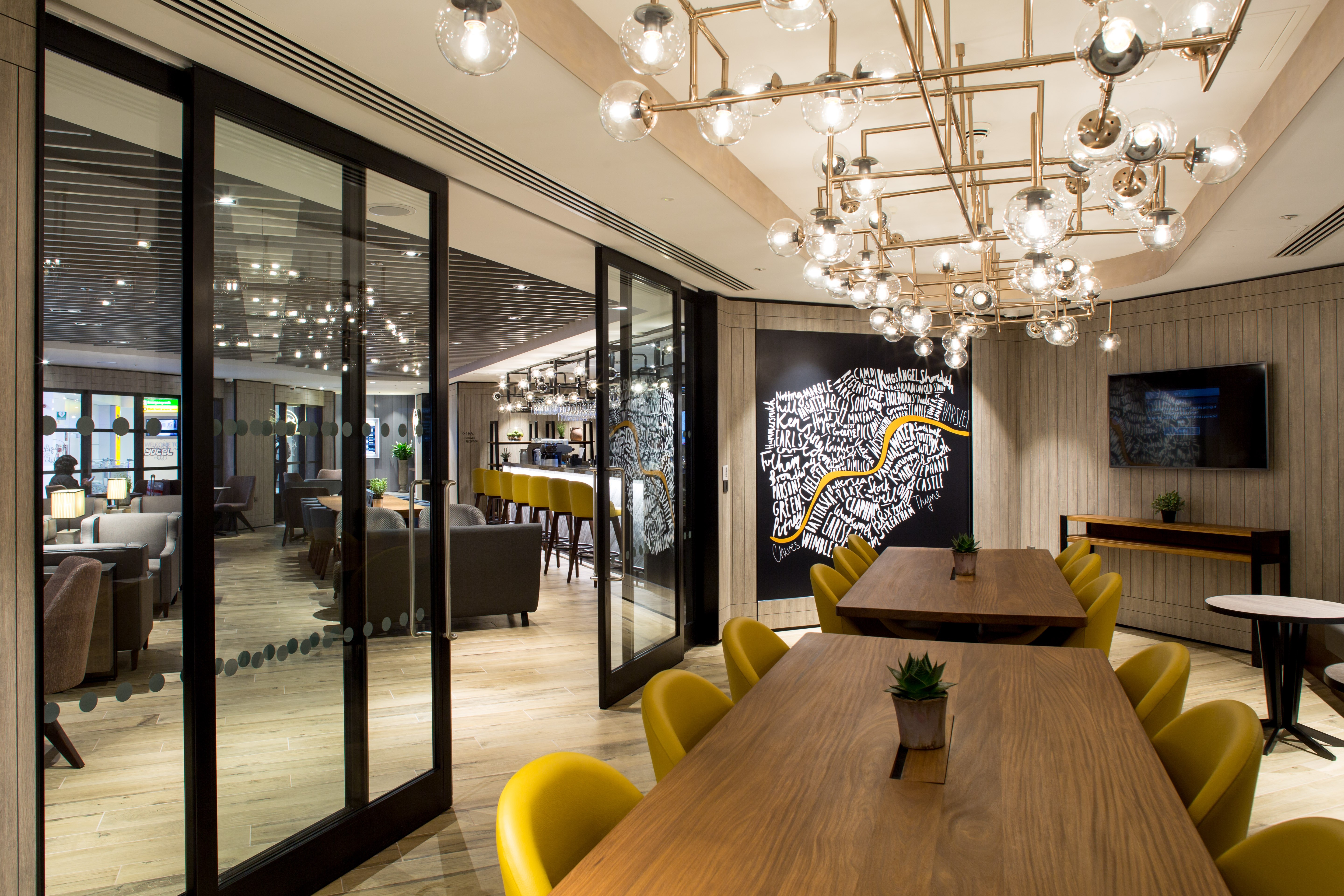 Modern meeting room with wooden table and yellow chairs for collaborative events.