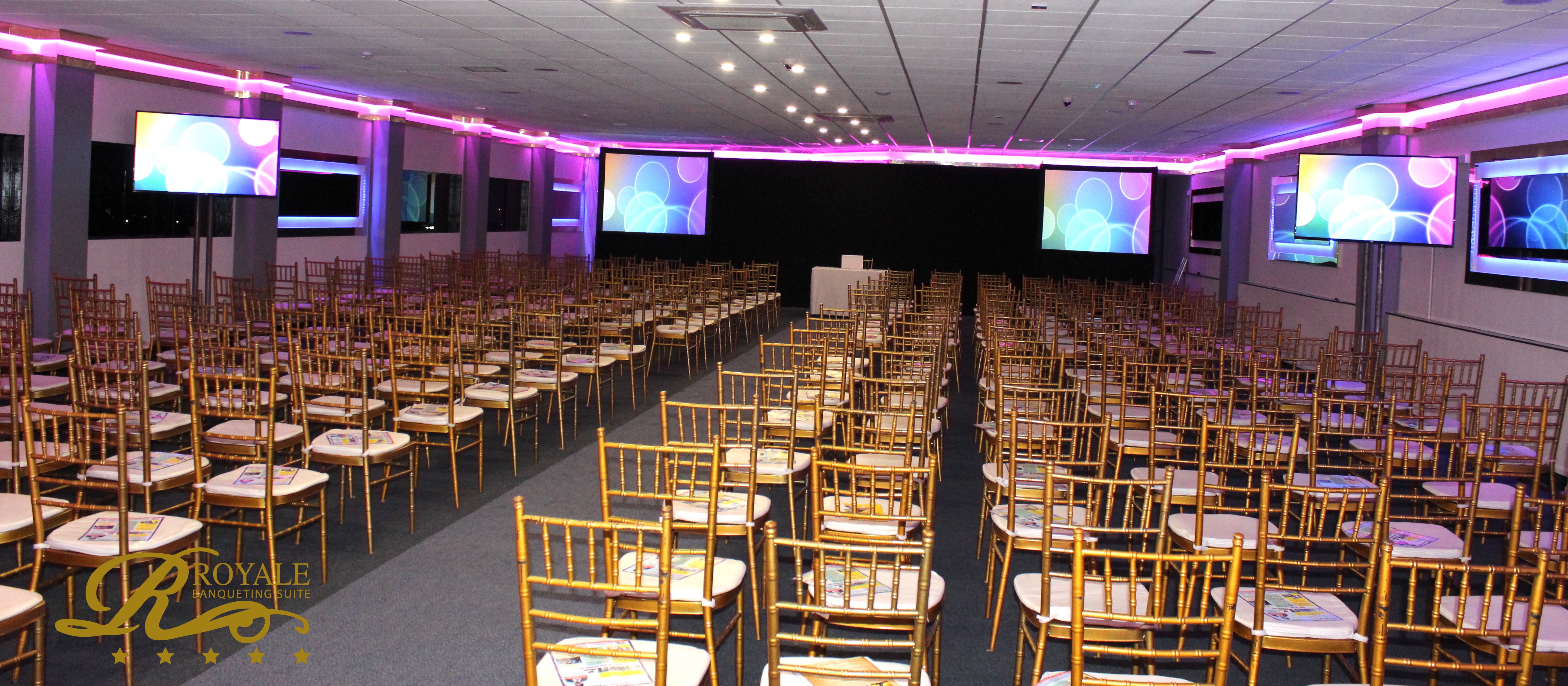 Golden Suite at Royale Banqueting, elegant chairs for a conference presentation.