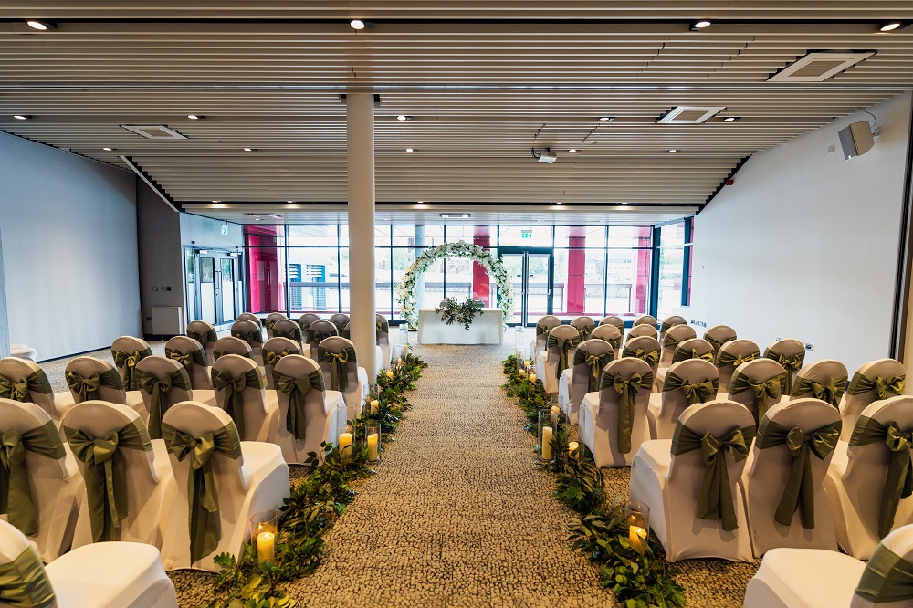 Wedding ceremony setup at Pier Eight Room with neutral decor and pillar for modern event planning.