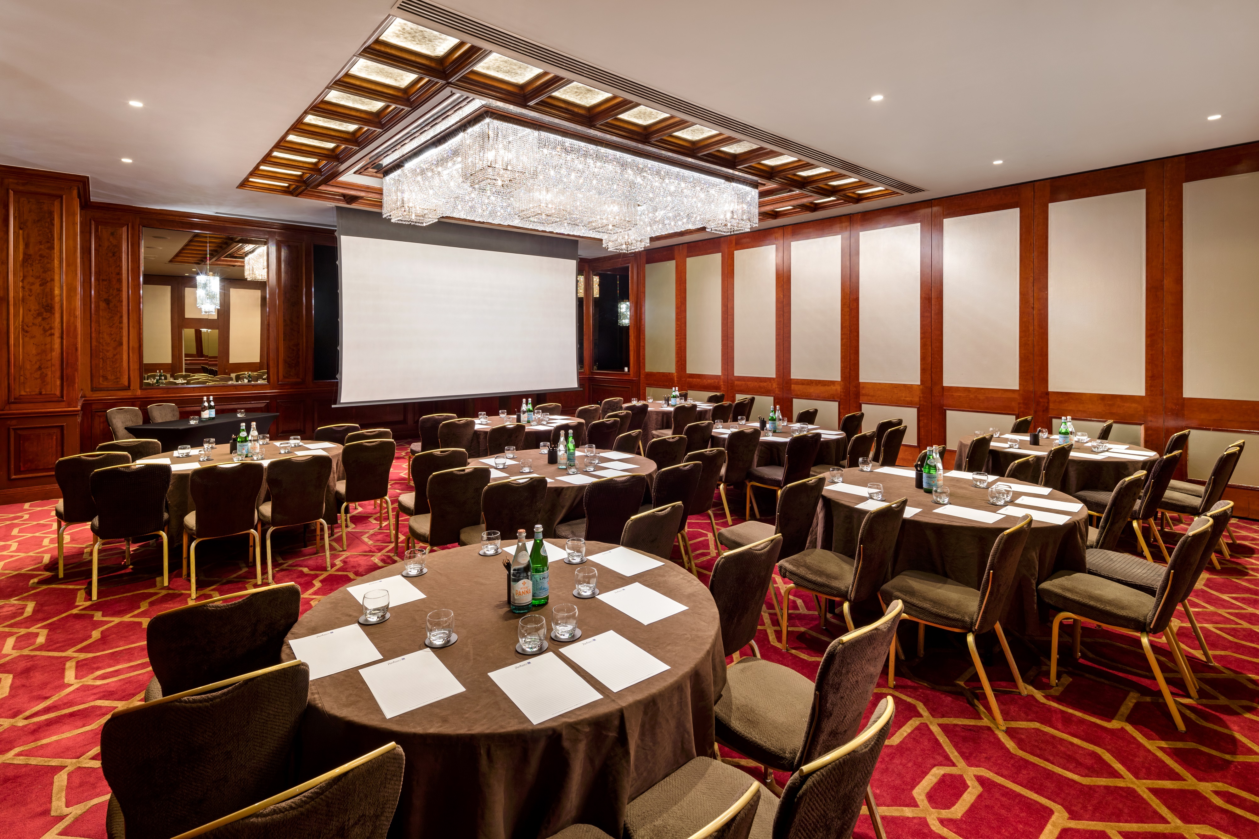 Corporate meeting room with round tables, ideal for workshops and presentations.