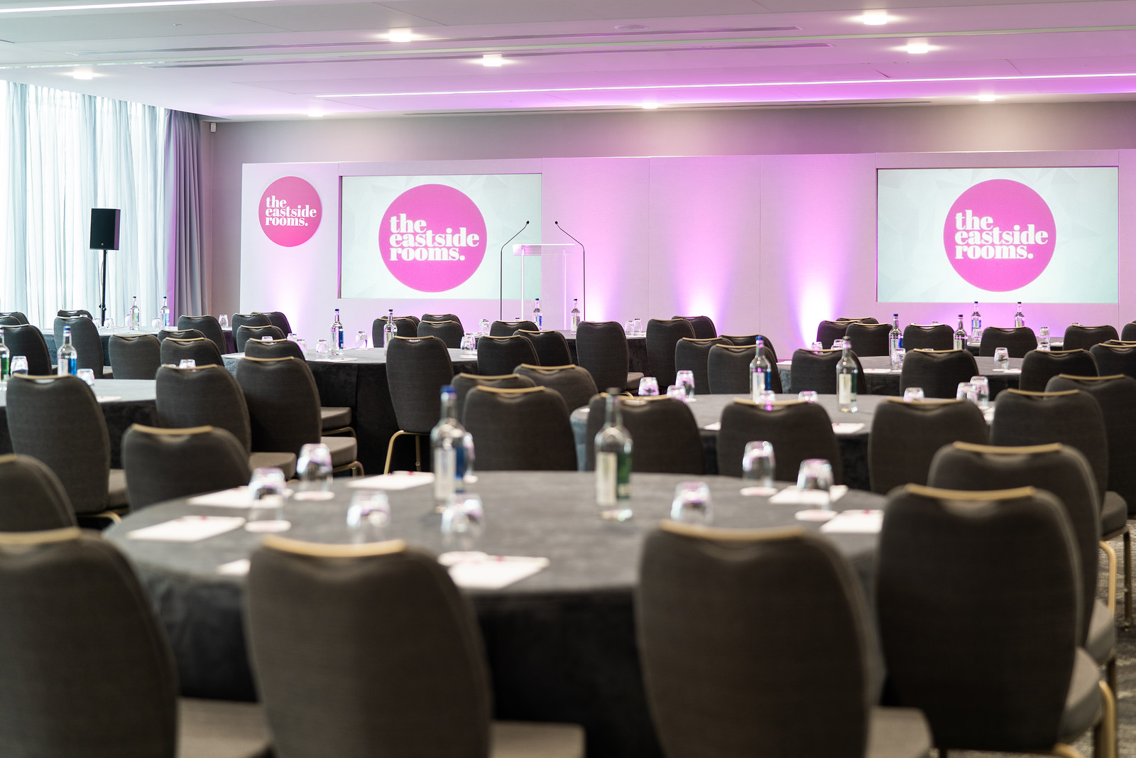 Ashtead Suite conference room with round tables, ideal for meetings and networking events.