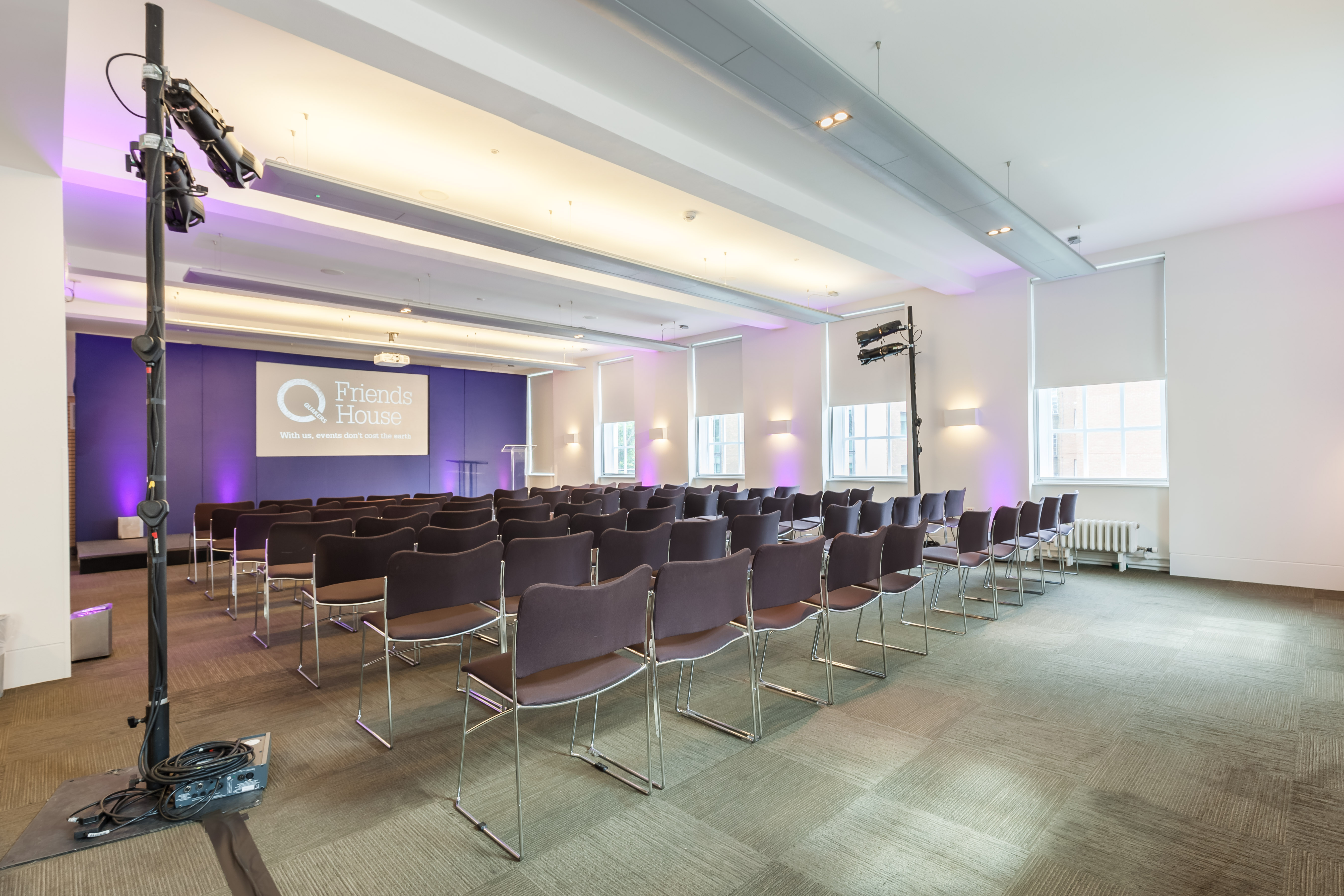 Event space at Friends House with purple lighting, ideal for presentations and meetings.