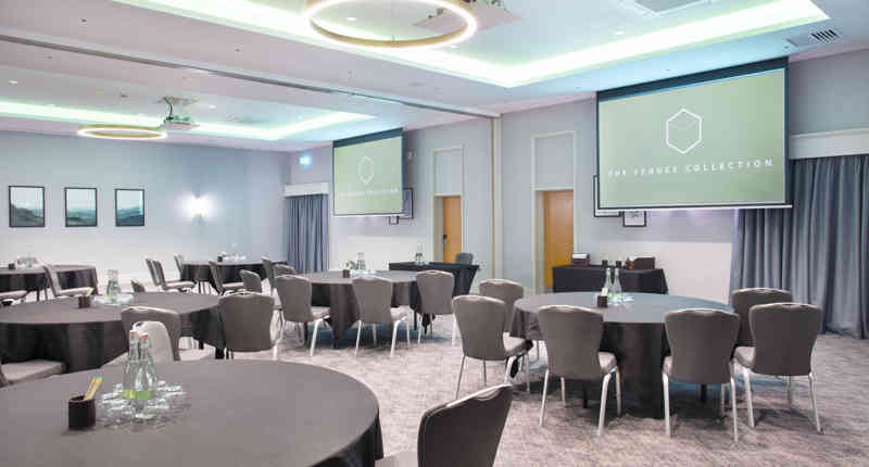 Modern event space at Sedgebrook Hall with round tables for corporate meetings. - Banner
