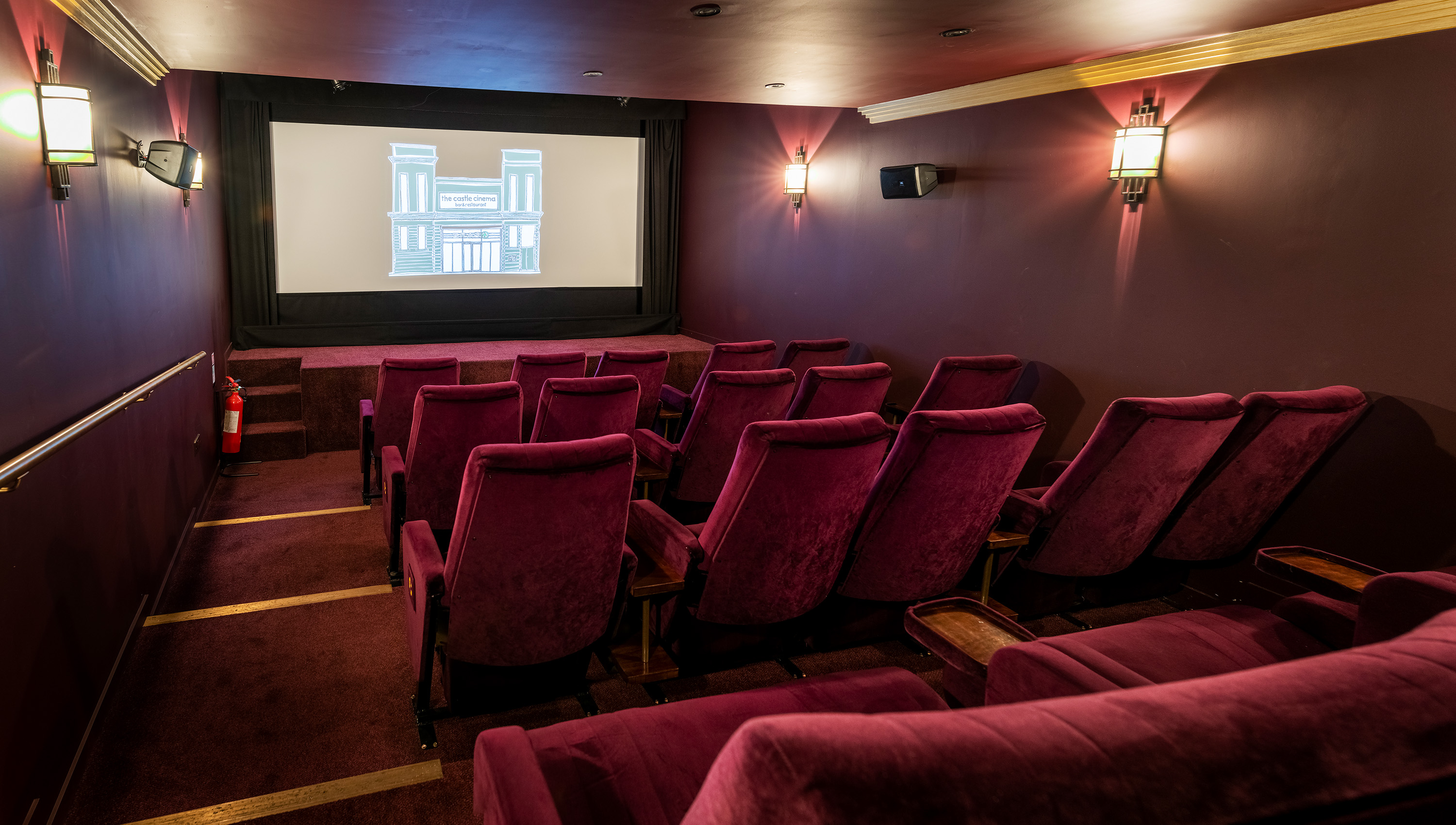 Cozy screening room with plush burgundy seating for private film events and presentations.