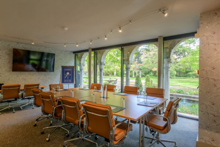 The Rose Room at Warren House Hotel, featuring a large table and natural light for meetings.