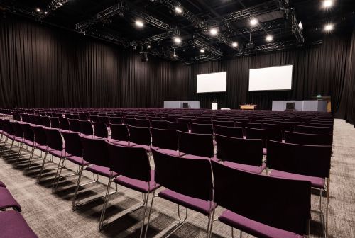 ICC Belfast conference venue with empty chairs and stage, perfect for presentations and workshops.