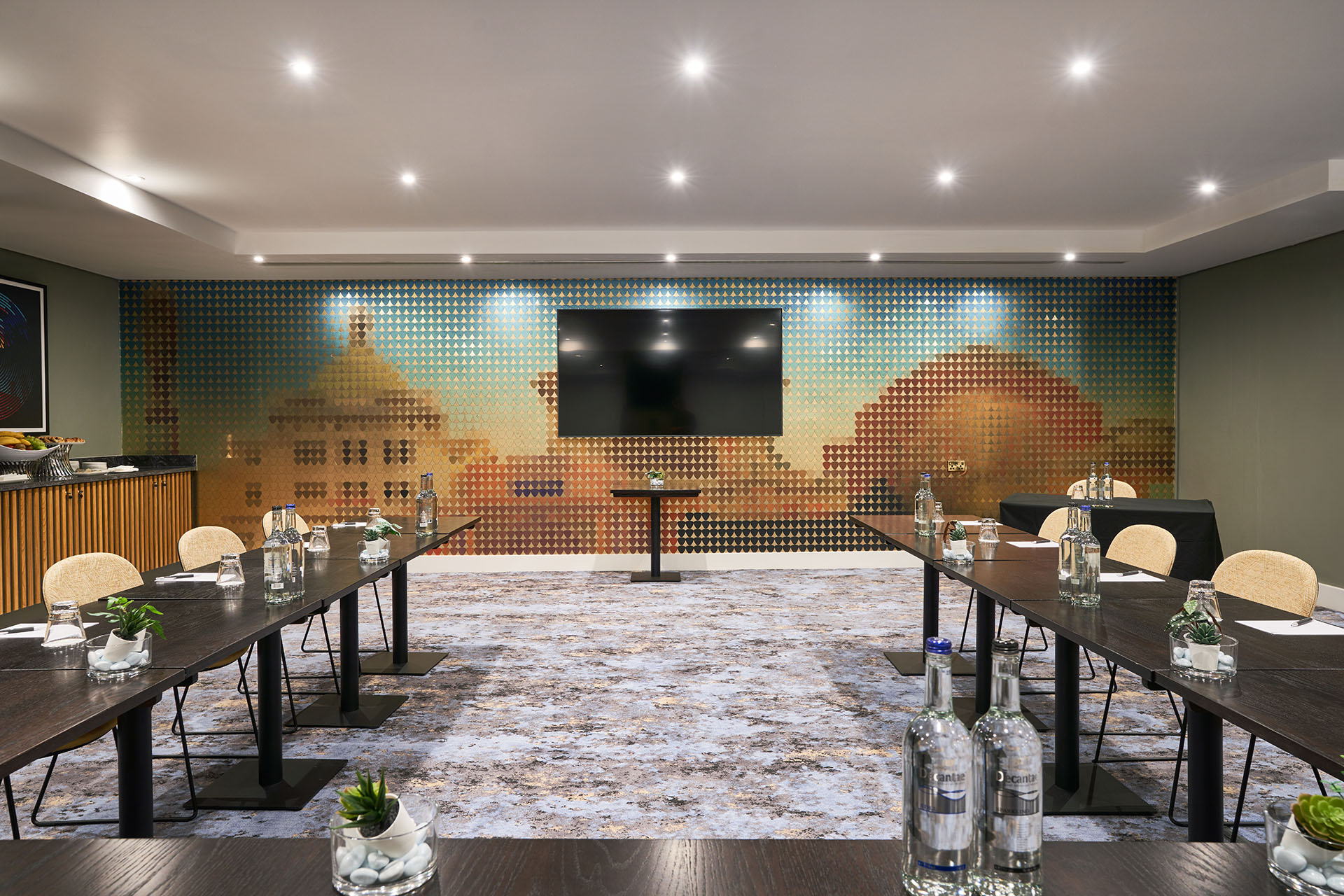 Modern meeting room at The Cumberland Hotel with dark wood tables and artistic mural. - Banner