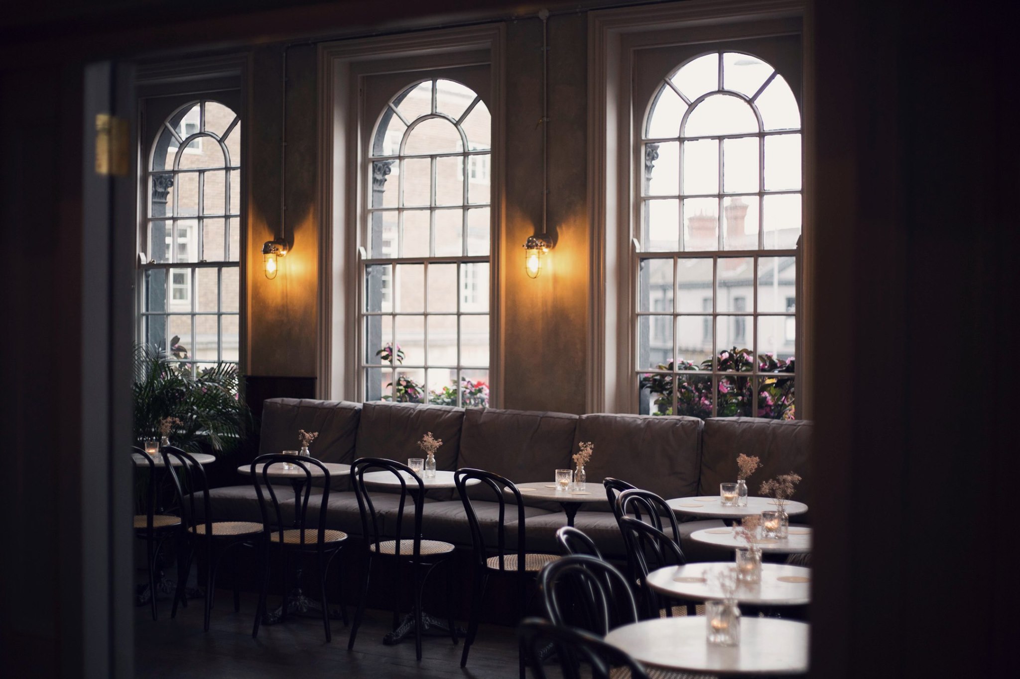 Cozy lounge with arched windows, perfect for intimate gatherings and networking events. - Banner