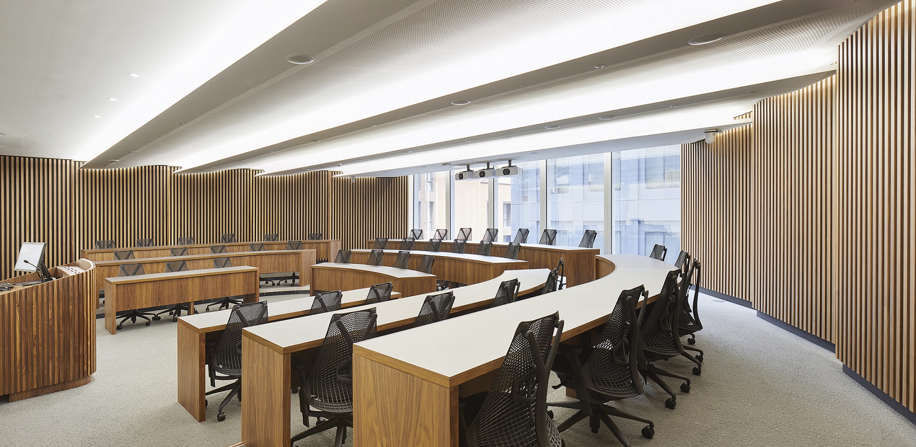 Modern executive conference room with curved seating for workshops and strategic planning sessions. - Banner