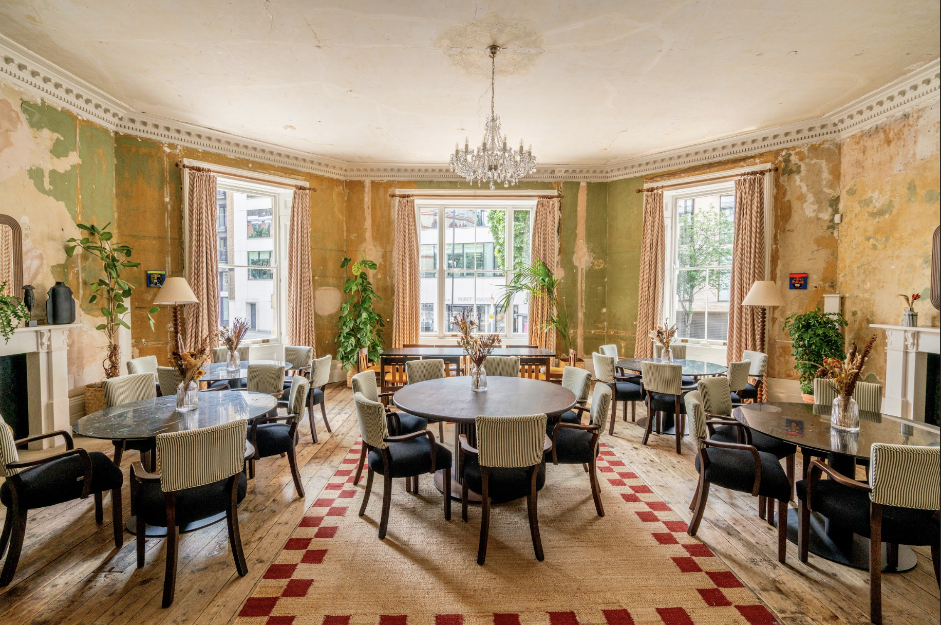 Charming dining room with round tables for meetings at Knotel Workclub, ideal for gatherings.