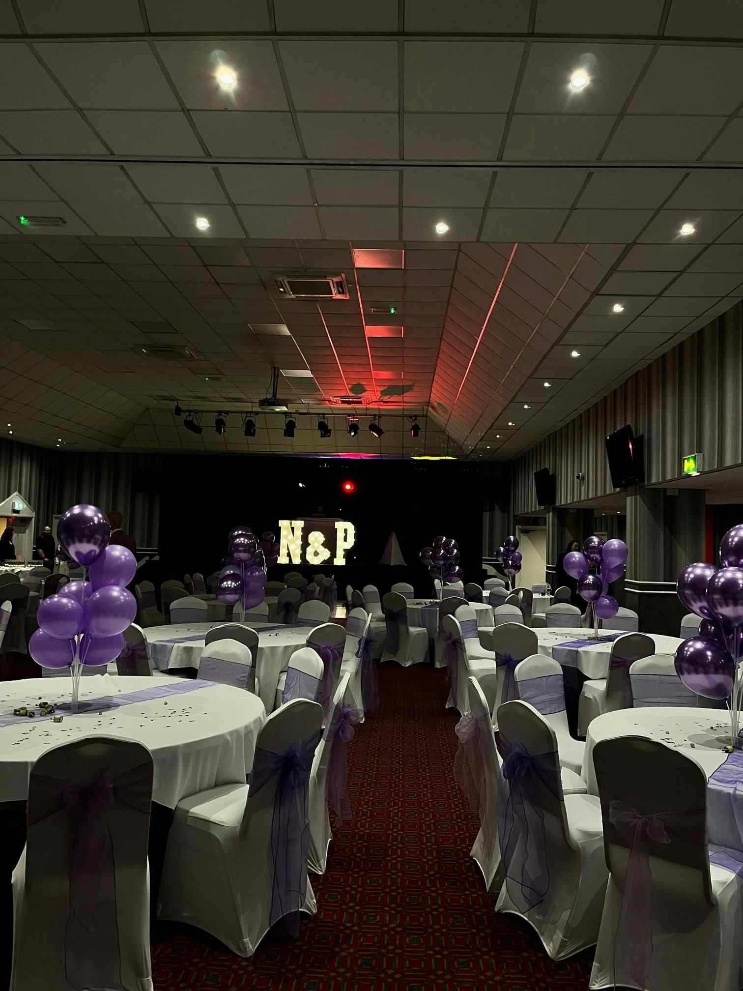 Elegant event space with purple balloons, ideal for celebrations and corporate gatherings. - Banner