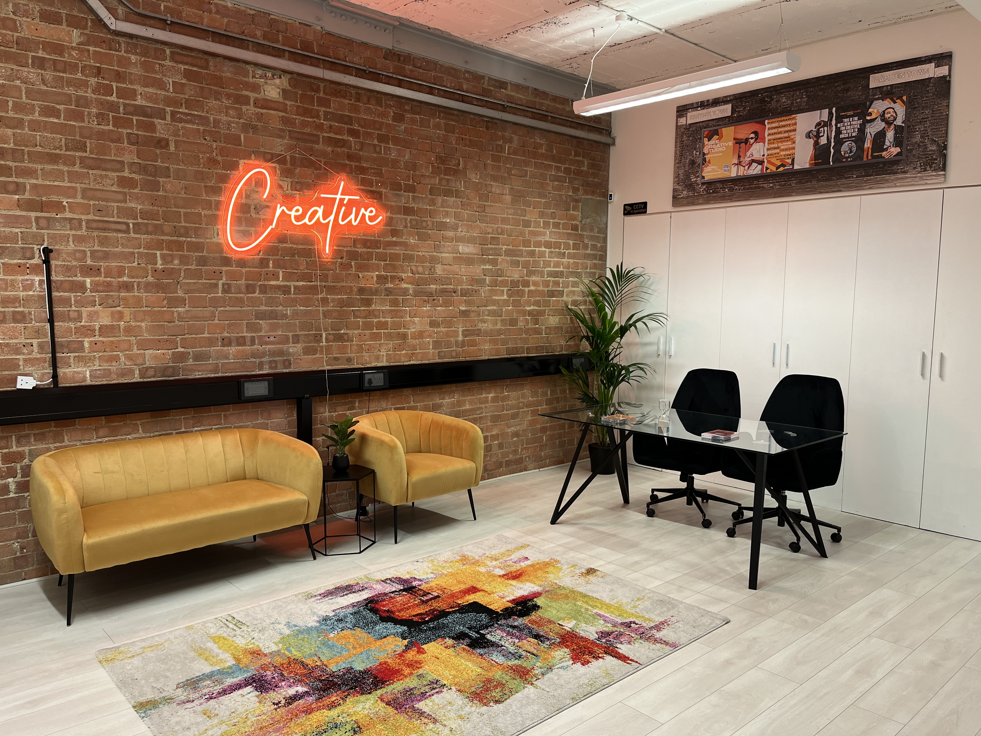 Creators House meeting studio with neon sign, ideal for intimate brainstorming and workshops.