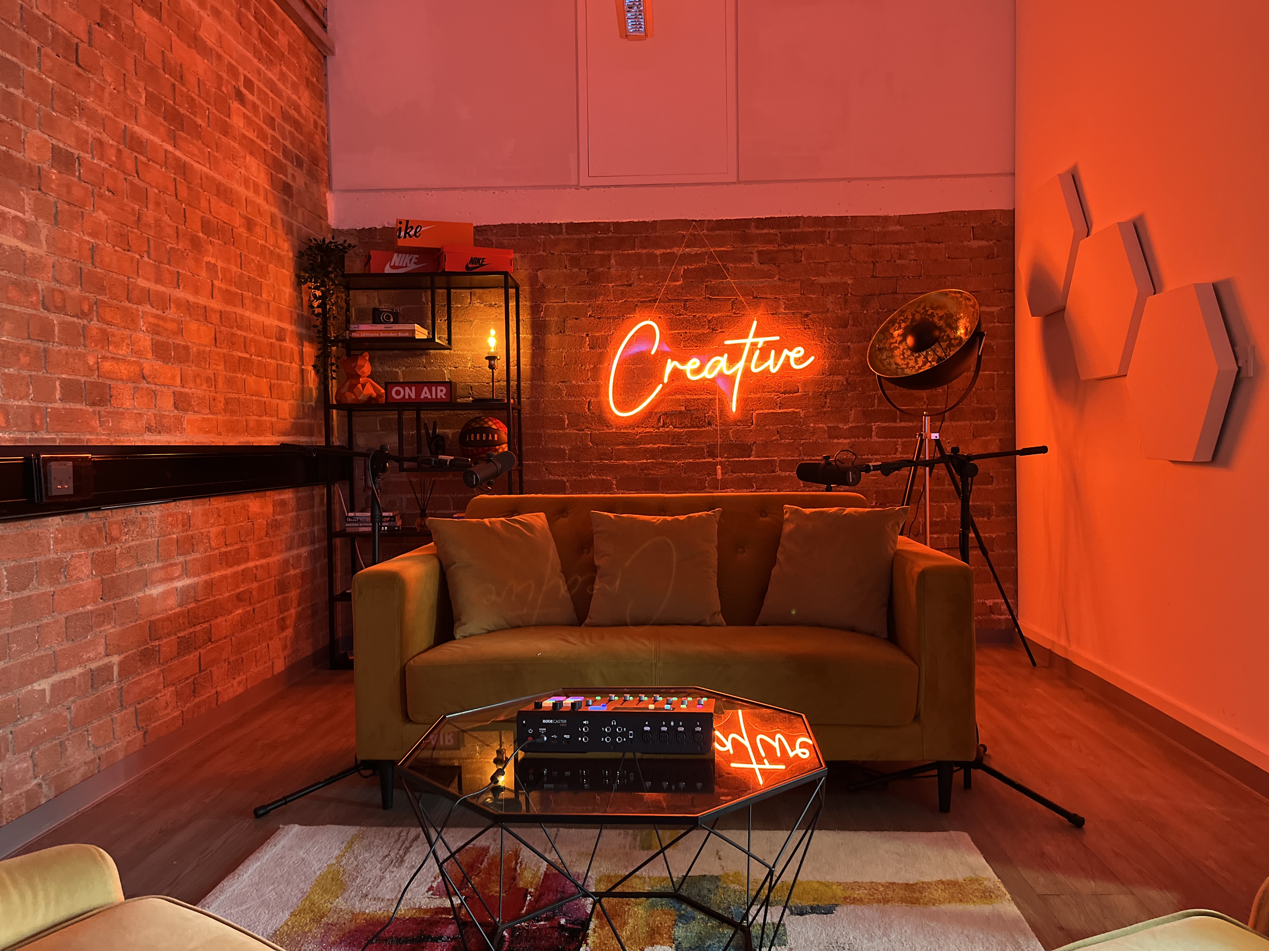 Creators House studio with brick walls and neon sign for podcast recording and breakout sessions.