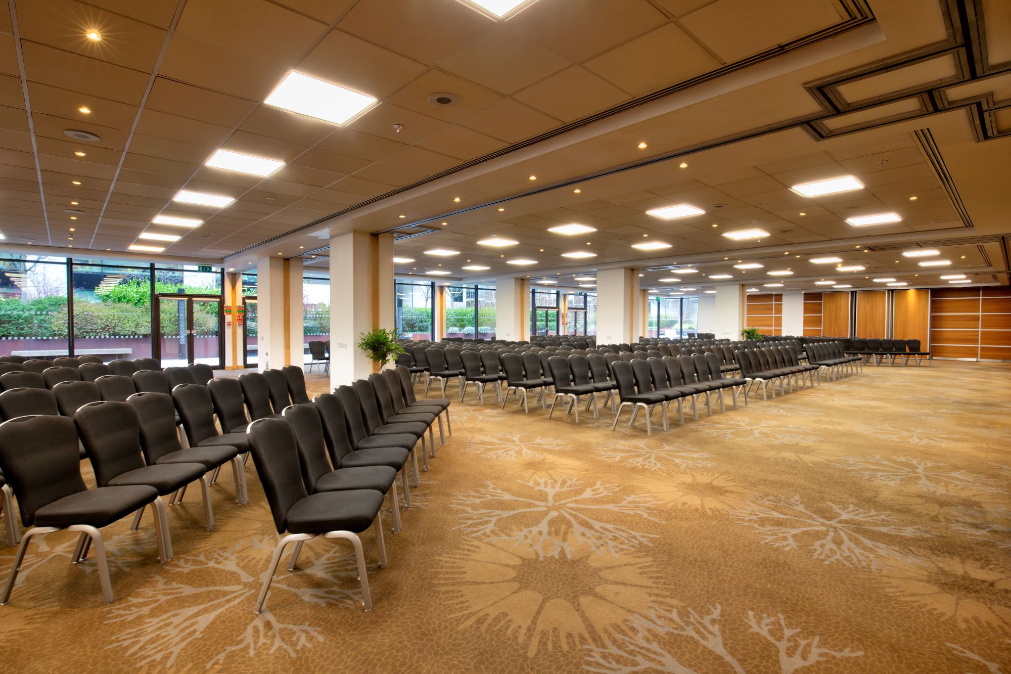 Spacious conference room at Novotel London West with black chairs and natural light.