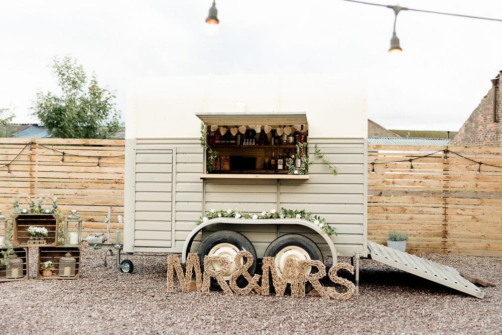 Mobile horse-trailer bar in outdoor courtyard at The Barn at Morleys Hall for rustic weddings.