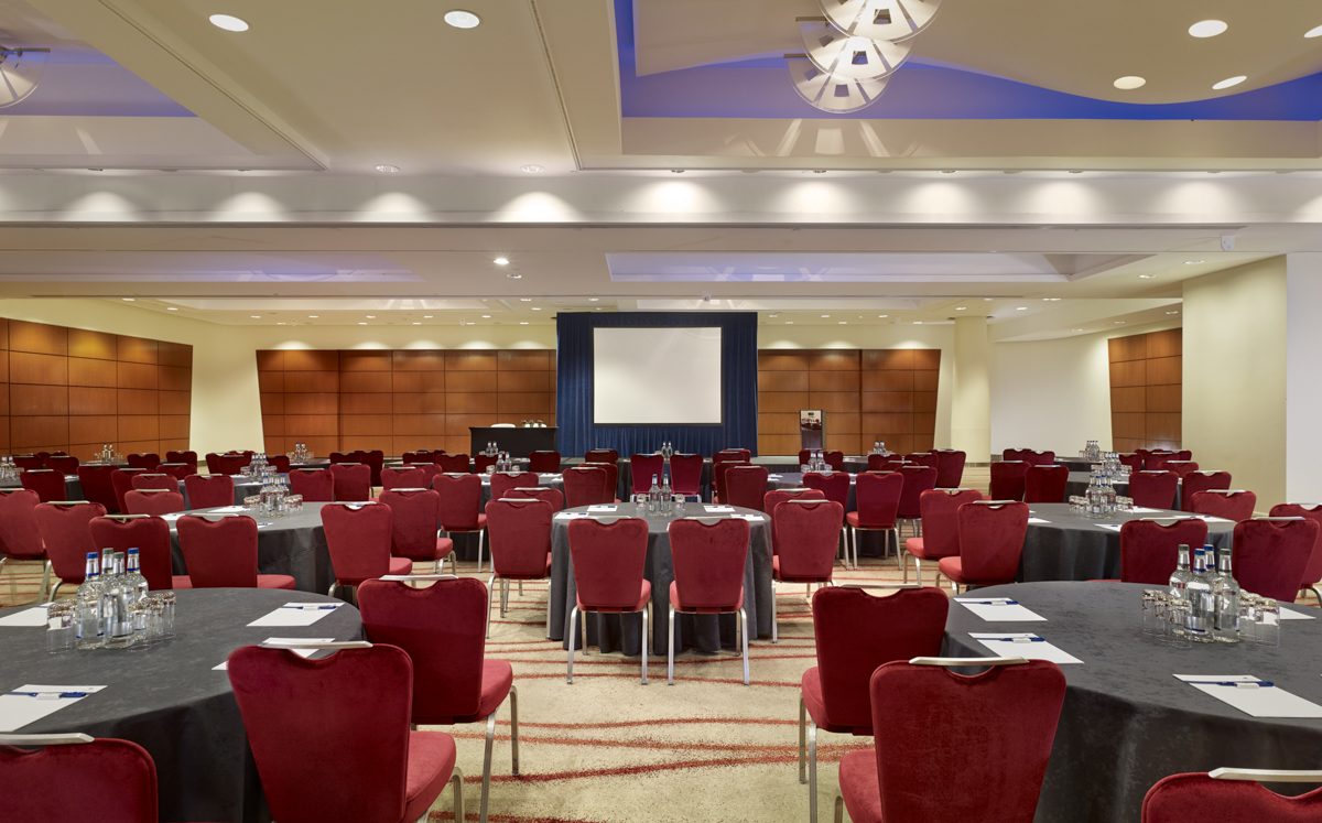 Victoria Suite at Park Plaza Victoria London, ideal for conferences with round tables and red chairs. - Banner