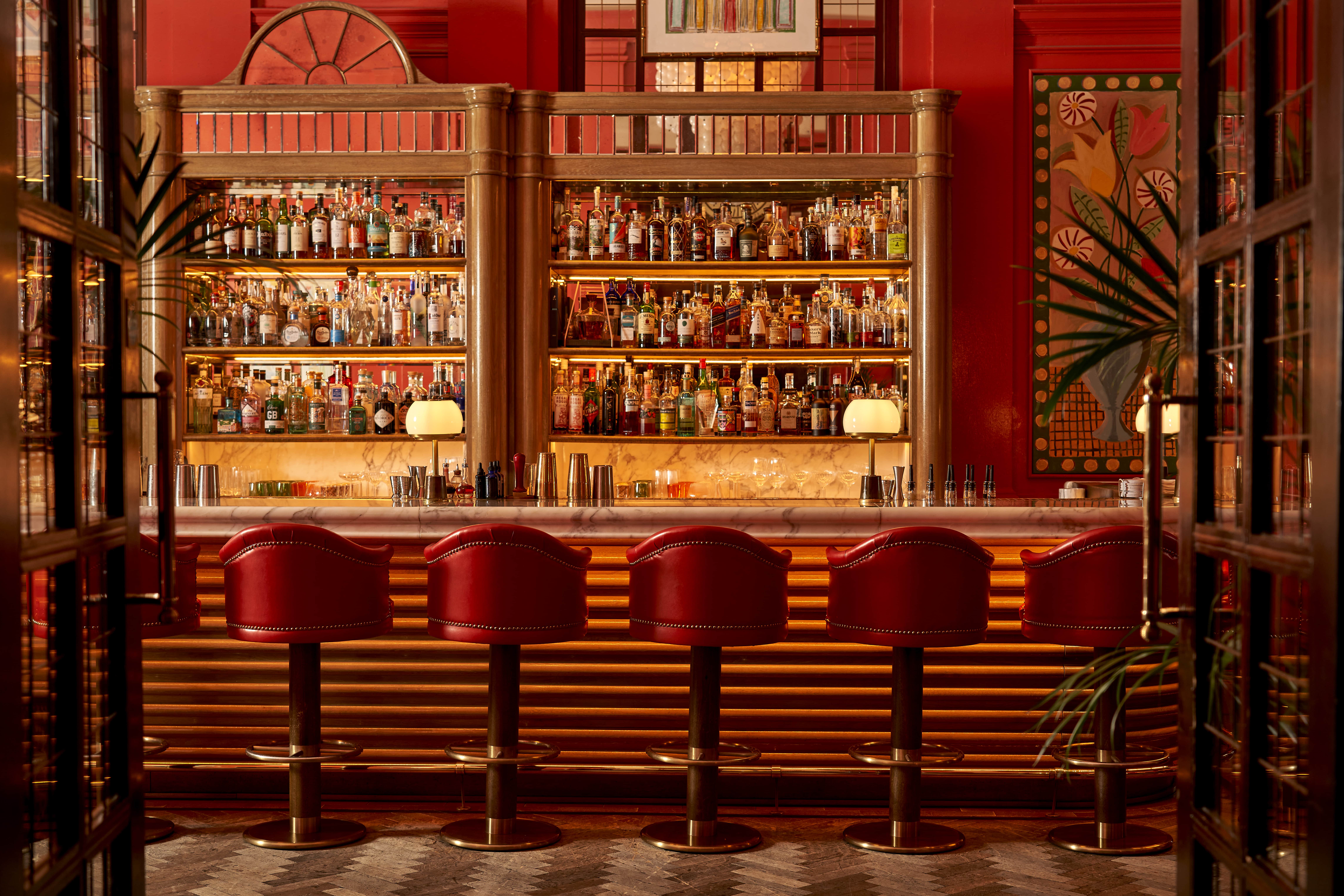 Stylish Coral Room bar with rich red walls, perfect for cocktail receptions and networking.