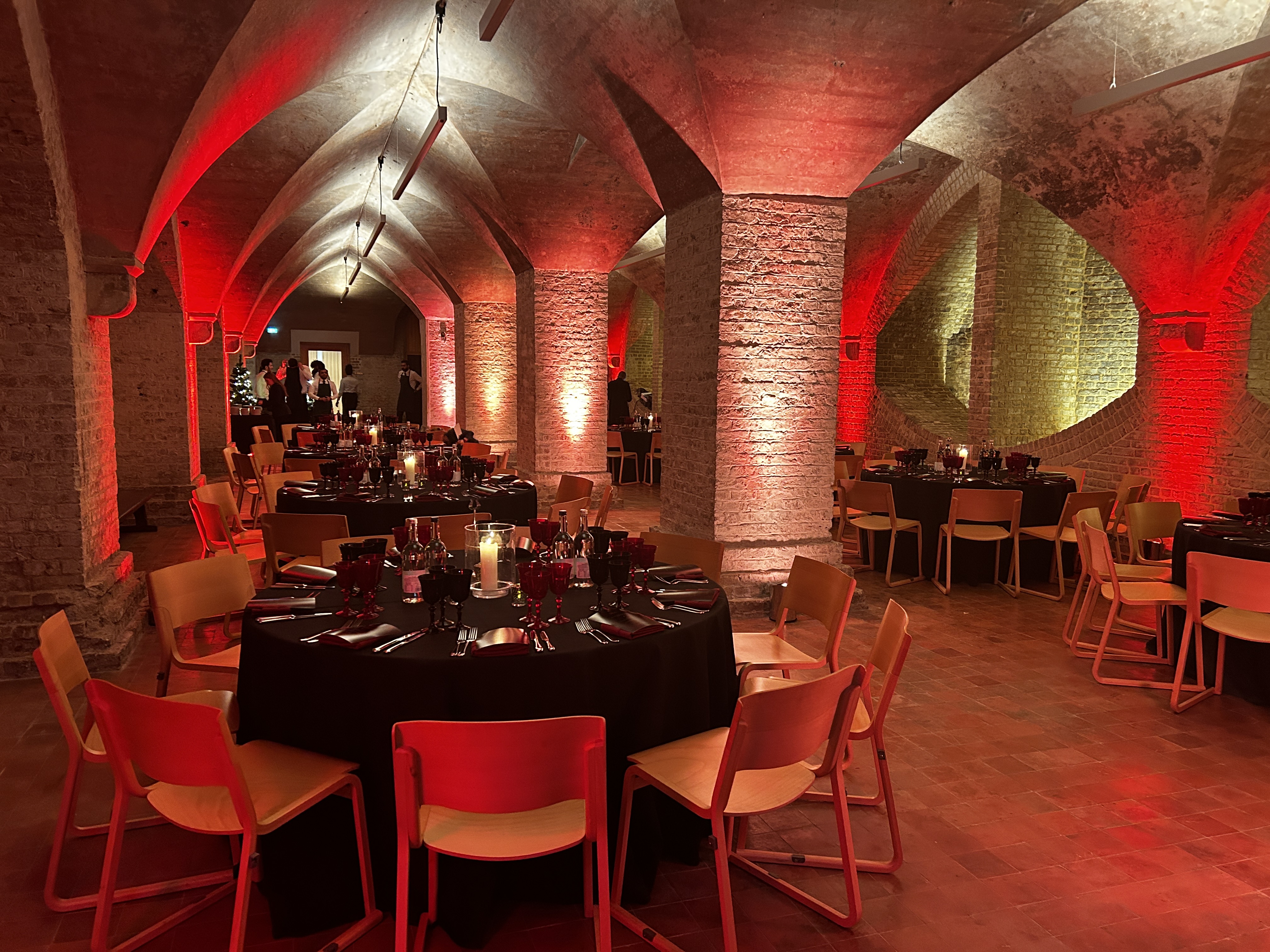 Elegant event space with round tables and warm lighting, perfect for gala or corporate dinner.