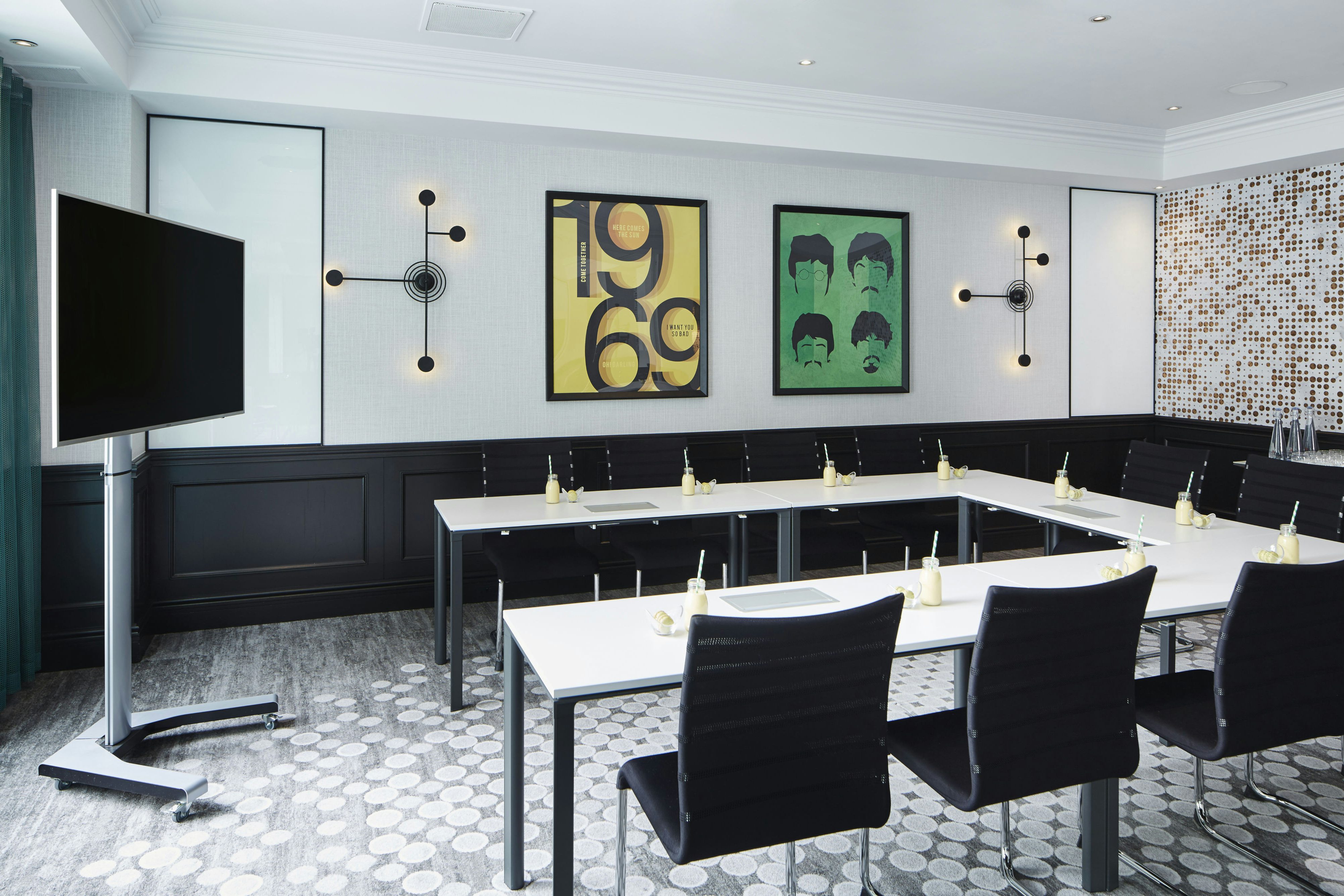 Modern boardroom with U-shape seating and AV display for London business meetings and conferences.
