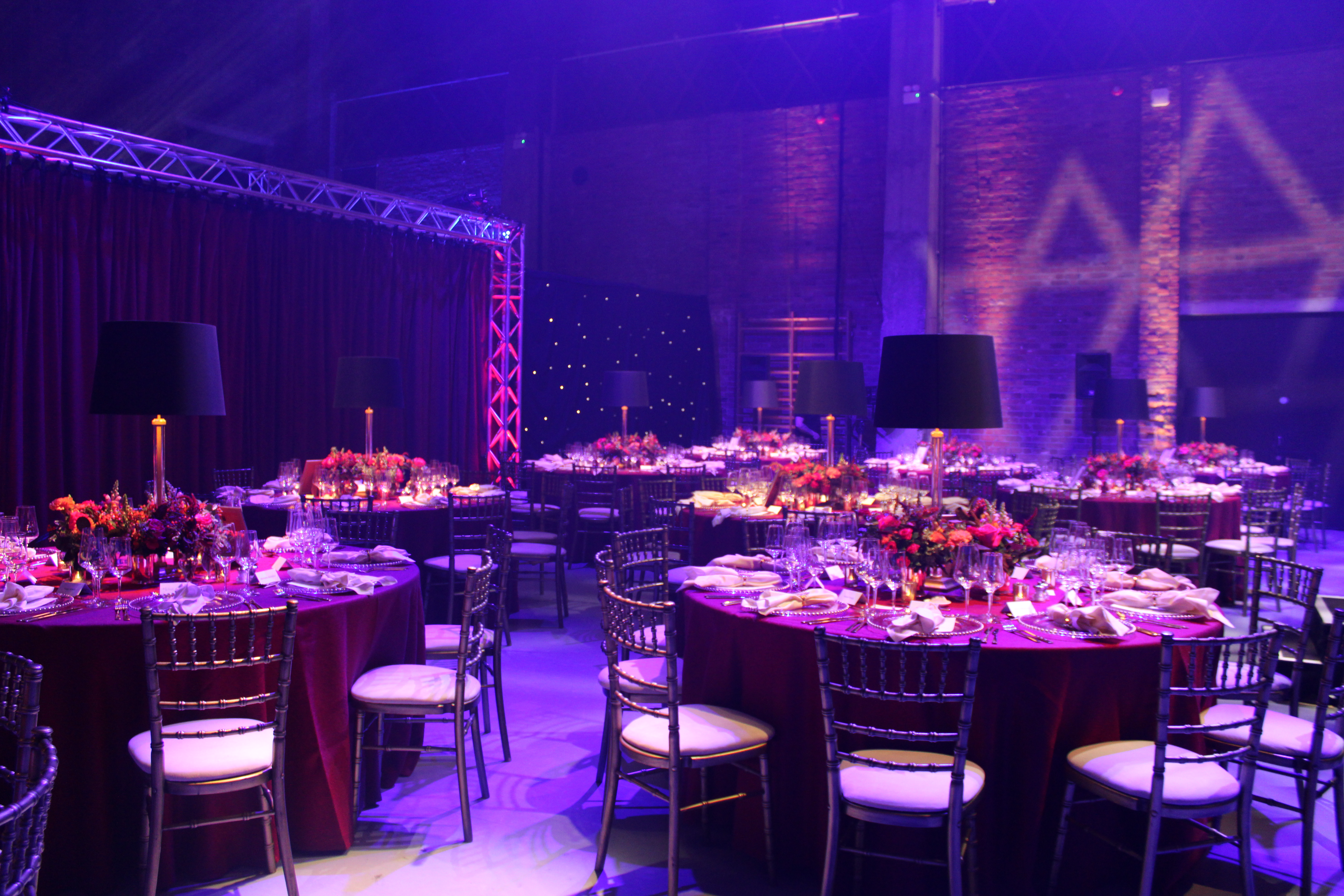 Upscale gala at Shoreditch Electric venue featuring rich velvet draping and dramatic lighting.