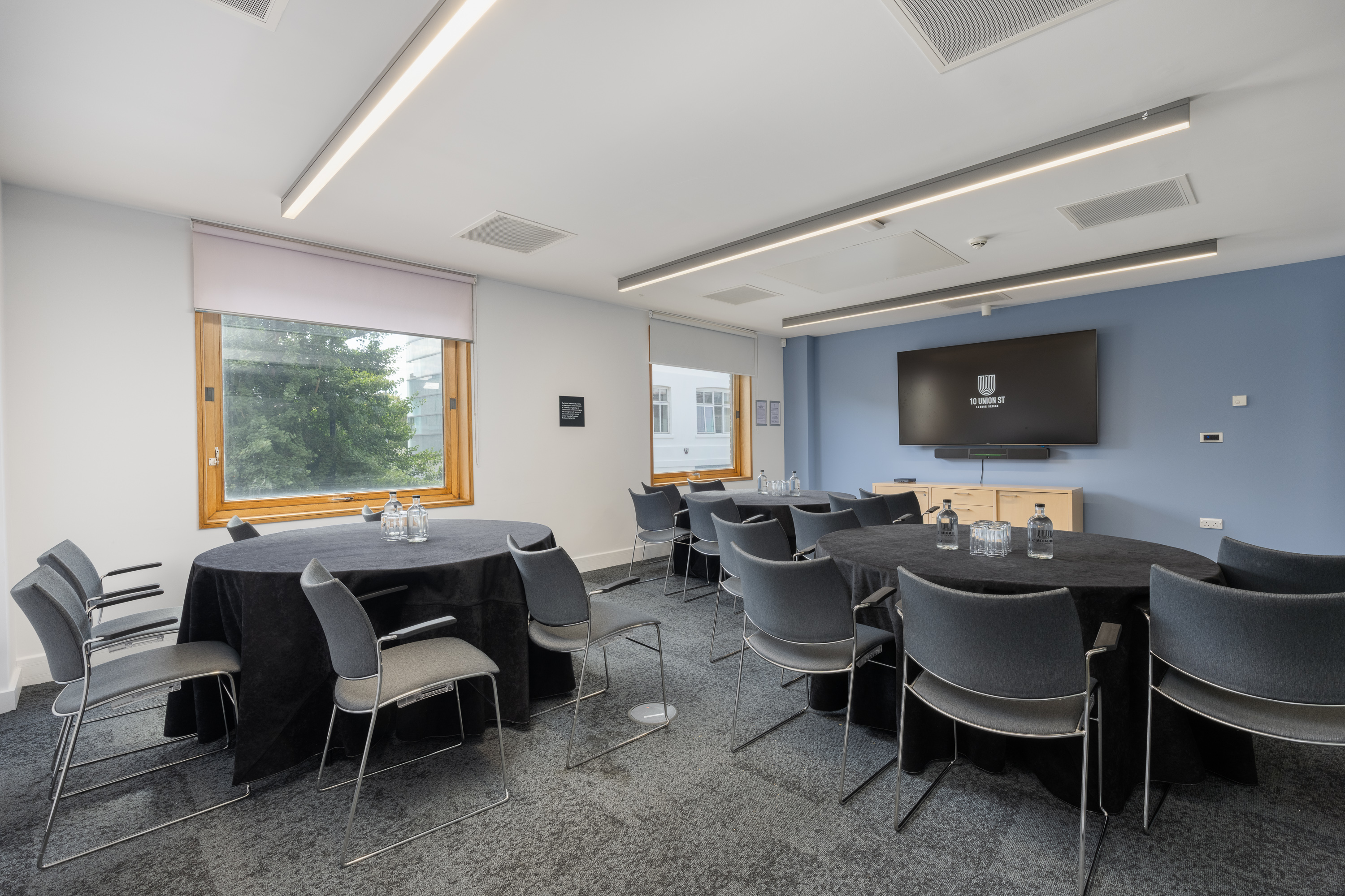 Modern breakout room with round tables for collaborative workshop and meeting events.