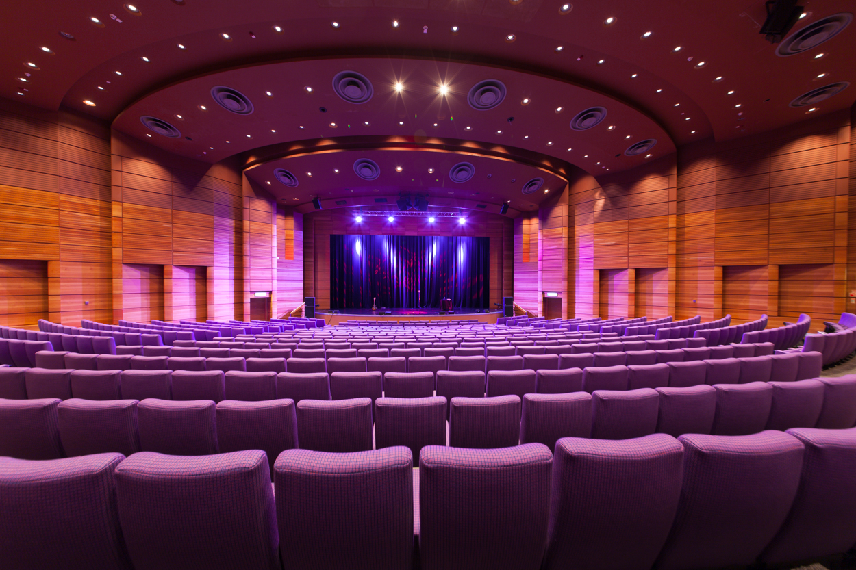 Pentland Auditorium with tiered purple seating, ideal for conferences and events. - Banner
