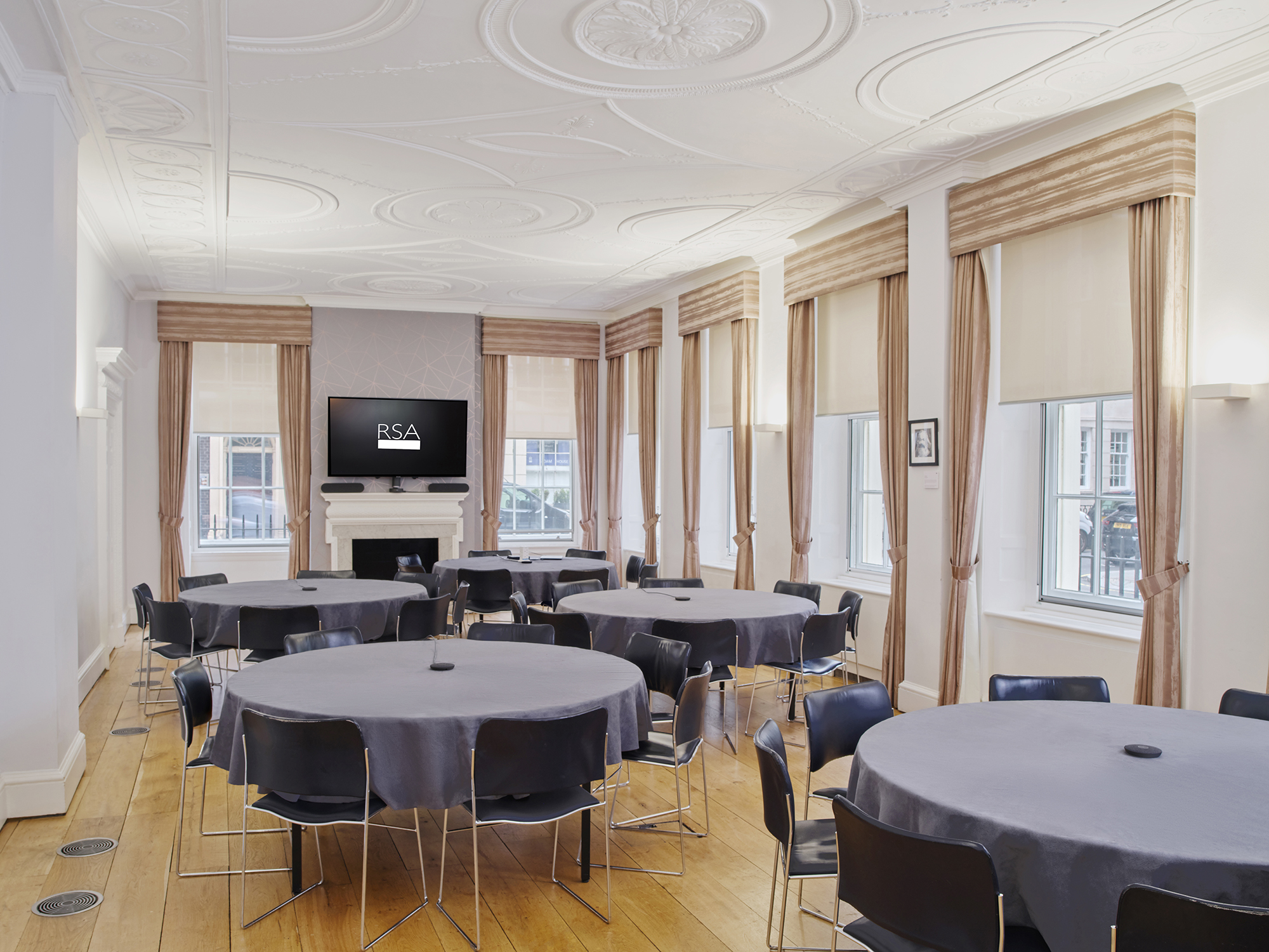 Tavern Room at RSA House: versatile meeting space with round tables and natural light.